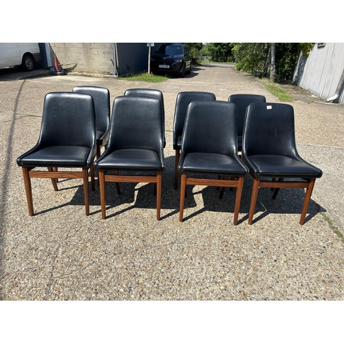 220 - A set of 8 mid century teak framed dining chairs with black vinyl upholstery