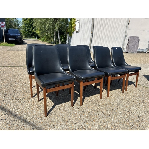 220 - A set of 8 mid century teak framed dining chairs with black vinyl upholstery