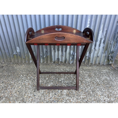 232 - A mahogany butlers tray table on folding stand