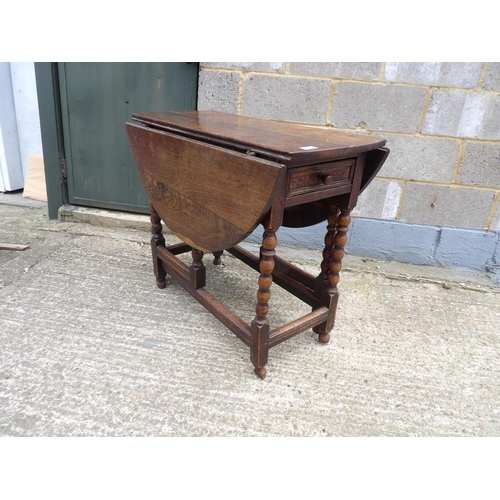 60 - An antique oak gateleg table with drawer to each end