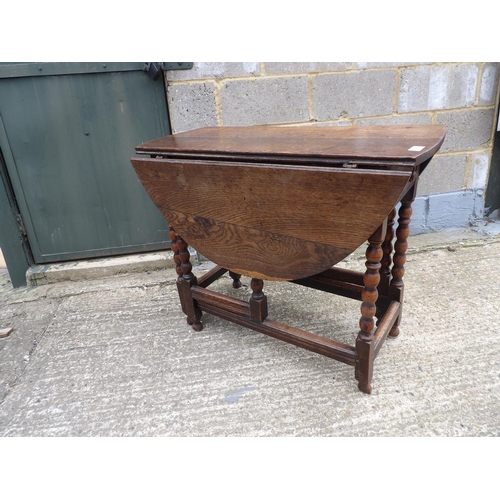 60 - An antique oak gateleg table with drawer to each end