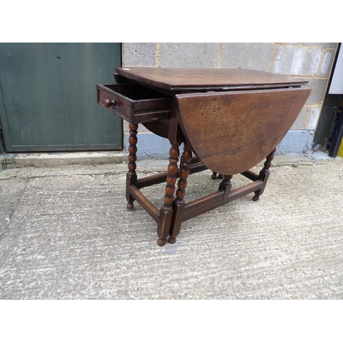 60 - An antique oak gateleg table with drawer to each end