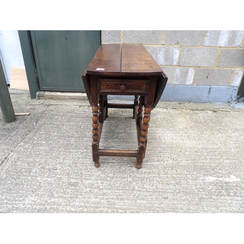 60 - An antique oak gateleg table with drawer to each end