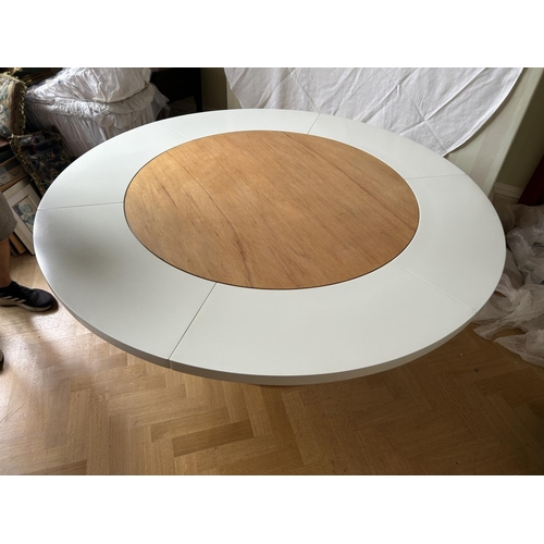 76 - A mid century circular dining table with 'trip trap' stlye extension leaves