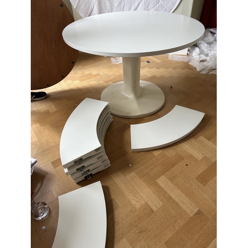 76 - A mid century circular dining table with 'trip trap' stlye extension leaves