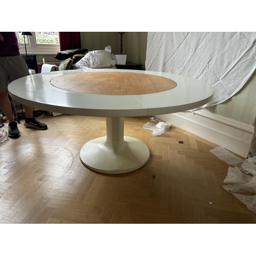 76 - A mid century circular dining table with 'trip trap' stlye extension leaves