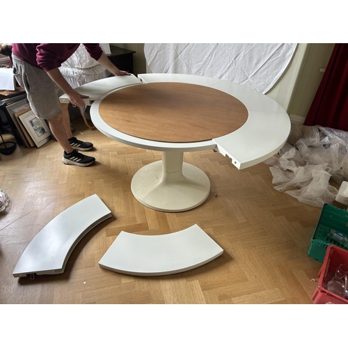 76 - A mid century circular dining table with 'trip trap' stlye extension leaves