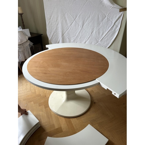 76 - A mid century circular dining table with 'trip trap' stlye extension leaves