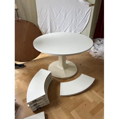 76 - A mid century circular dining table with 'trip trap' stlye extension leaves