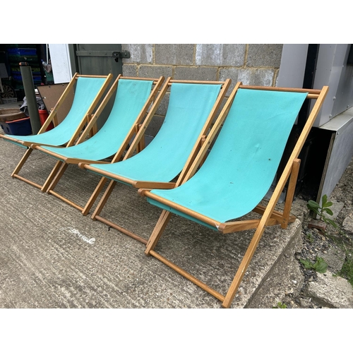 81 - Four light blue folding deck chairs