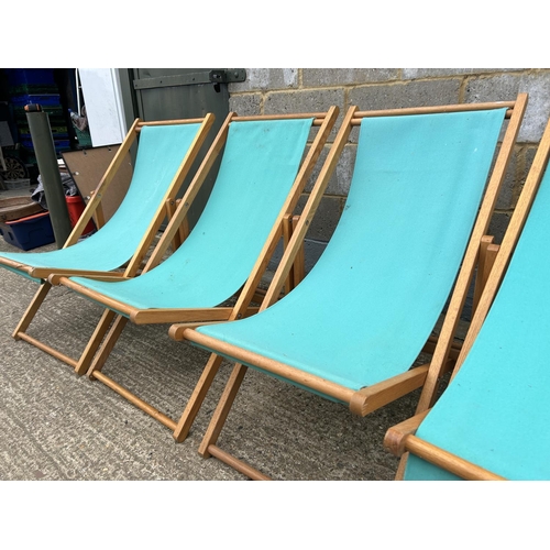 81 - Four light blue folding deck chairs