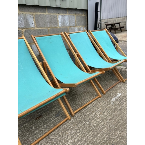 81 - Four light blue folding deck chairs