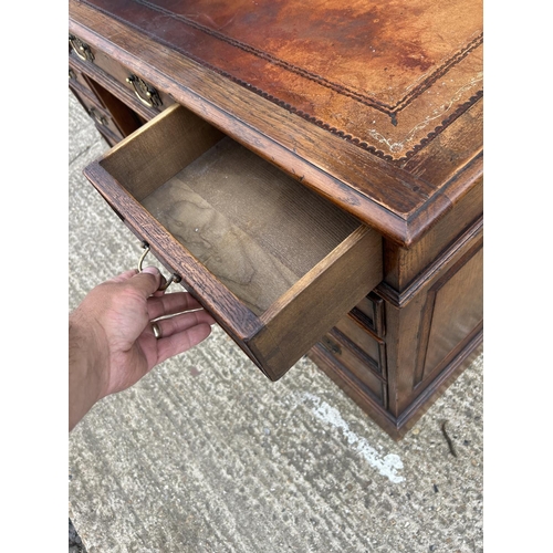 94 - A good quality reproduction oak twin pedestal desk with brown leather top 130x70x76