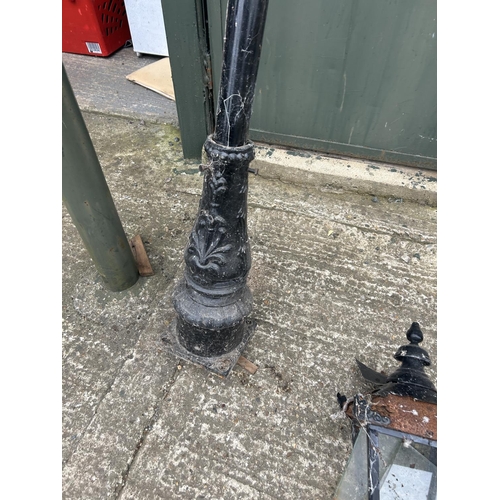 99 - A pair of iron lamp posts AF TO LANTERN TOPS