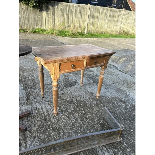 102 - An ash two drawer writing table, loom box, tea chest, occasional table and two brass fenders