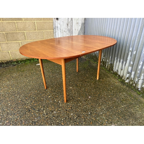 128 - A mid century teak swivel drop leaf dining table