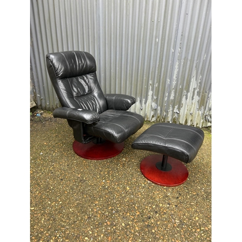 151 - A black leather reclining armchair with matching footstool