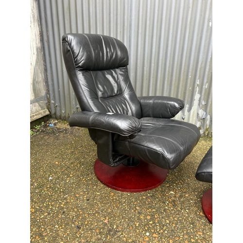 151 - A black leather reclining armchair with matching footstool