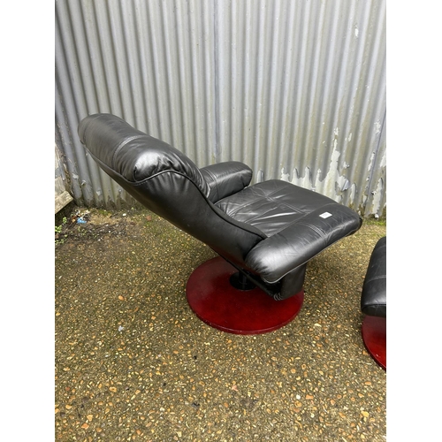 151 - A black leather reclining armchair with matching footstool