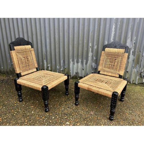 168 - A pair of african style low chairs with folding backs and cane seats