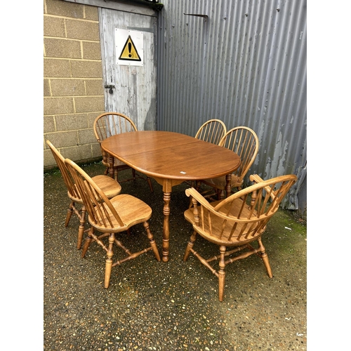 169 - An extending oak dining table together with a set of stick back chairs