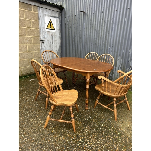 169 - An extending oak dining table together with a set of stick back chairs