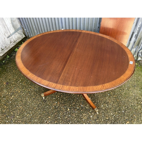 67 - A reproduction mahogany single pedestal dining table with extension leaf 138x106