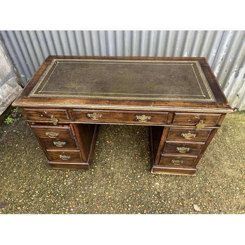 77 - An oak twin pedestal desk with green leather top