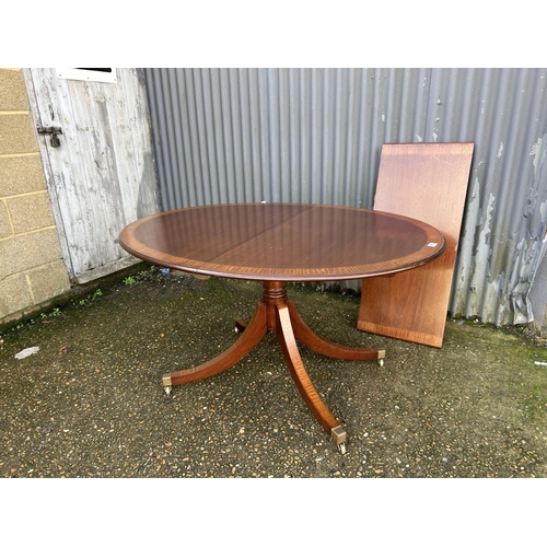 100C - A reproduction mahogany single pedestal dining table with extension leaf 138x106