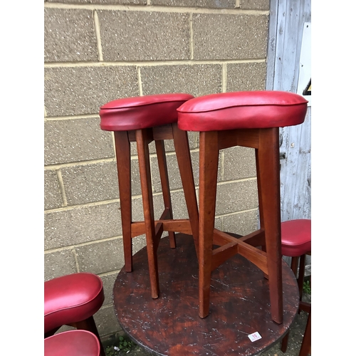 10 - A bentwood style circular cafe table together with six bar stools with red vinyl seats