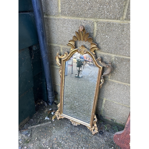 129 - An ornate gold gilt mirror together with a wall clock