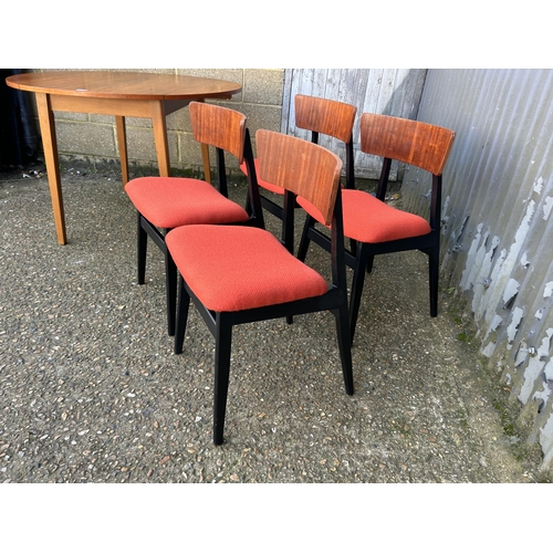 138 - A teak drop leaf dining table together with a set of four teak chairs with orange upholstered seats