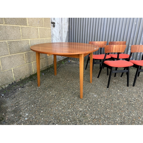 138 - A teak drop leaf dining table together with a set of four teak chairs with orange upholstered seats