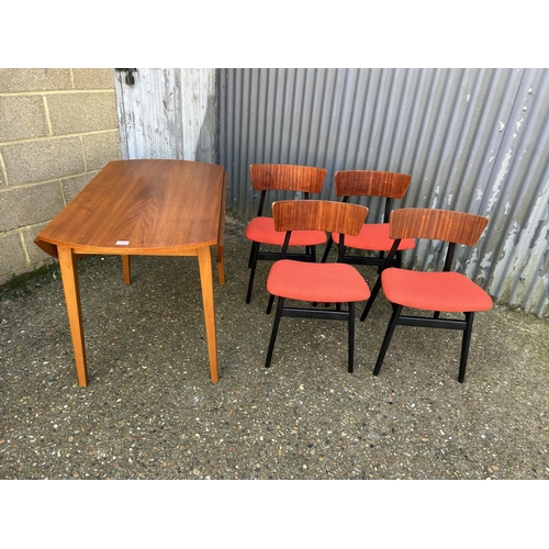 138 - A teak drop leaf dining table together with a set of four teak chairs with orange upholstered seats