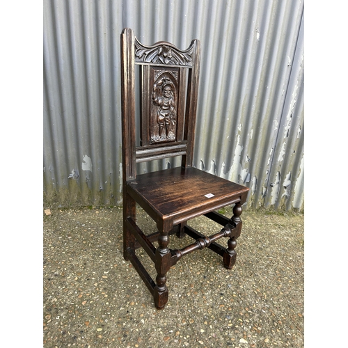 141 - A carved oak panel back chair