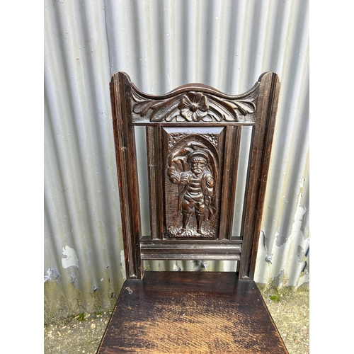 141 - A carved oak panel back chair