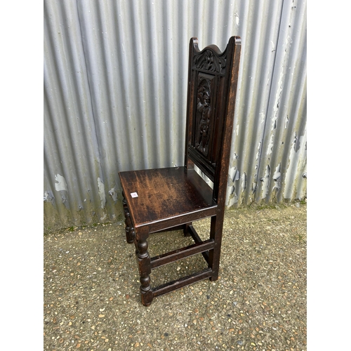 141 - A carved oak panel back chair