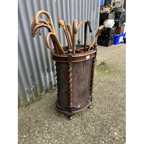 151 - An oak barley twist stick stand loaded with sticks