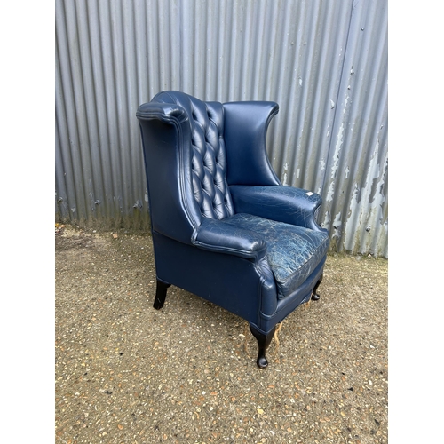 183 - A blue leather chesterfield wing back armchair