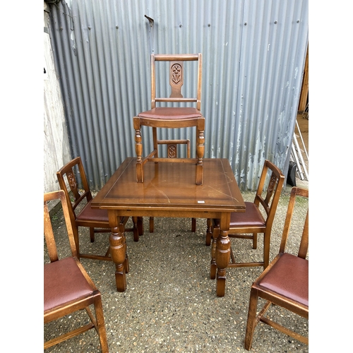 195 - A early 20th century oak drawer leaf table with six chairs