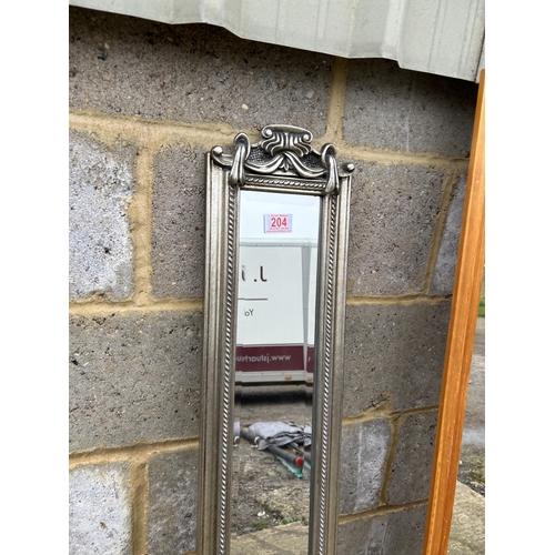 204 - A slim silver gilt mirror and another teak framed wall mirror