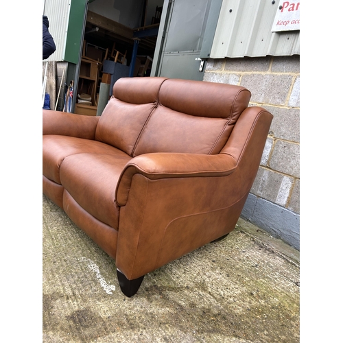 212 - A good quality soft brown leather two seater sofa by PARKER KNOLL approx one year old, still with la... 