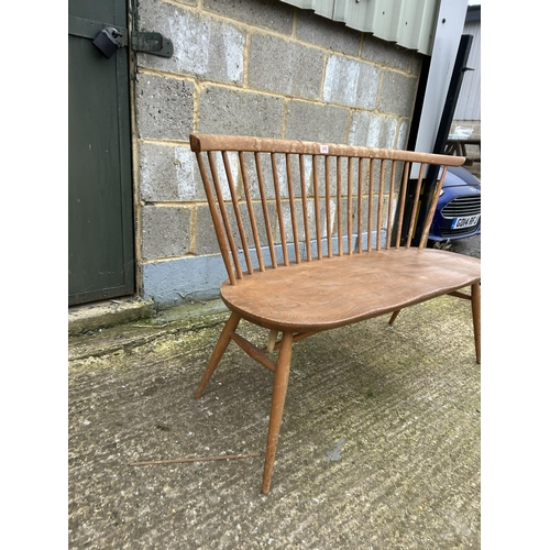 248 - An ercol light elm stick back bench seat