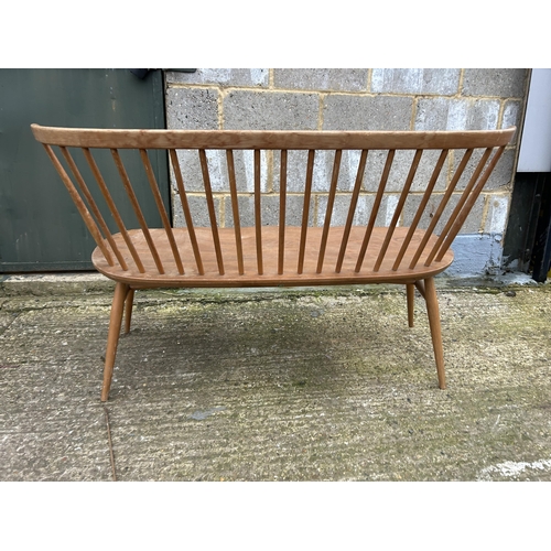 248 - An ercol light elm stick back bench seat