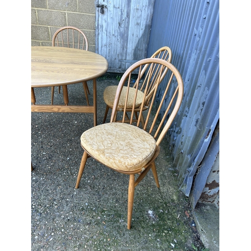 31 - A ercol light elm gate leg table with four stick back chairs