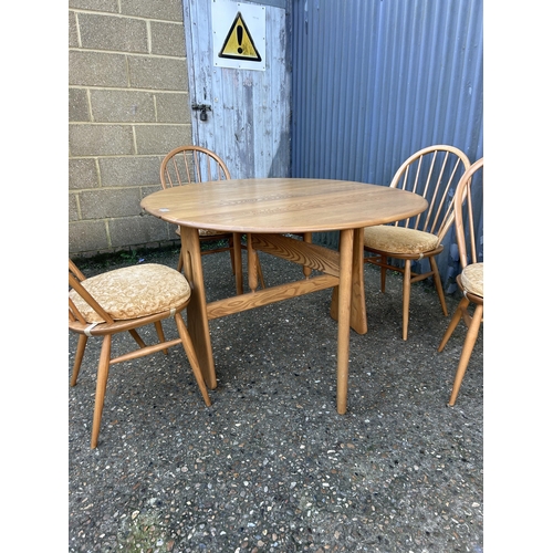 31 - A ercol light elm gate leg table with four stick back chairs