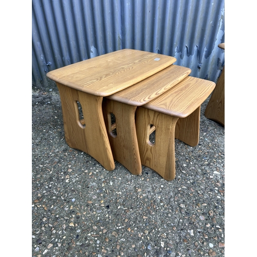 34 - A modern ercol light elm nest of three together with matching side table