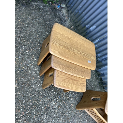 34 - A modern ercol light elm nest of three together with matching side table