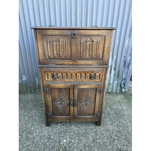 59 - An old charm carved oak drinks cabinet