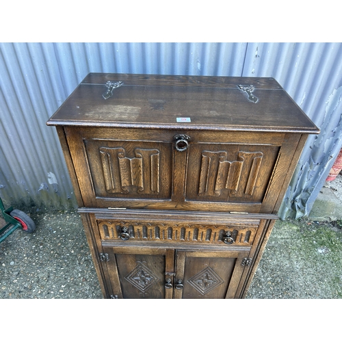 59 - An old charm carved oak drinks cabinet